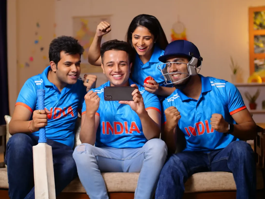Cricket Fans gucken auf ein Handy und jubeln