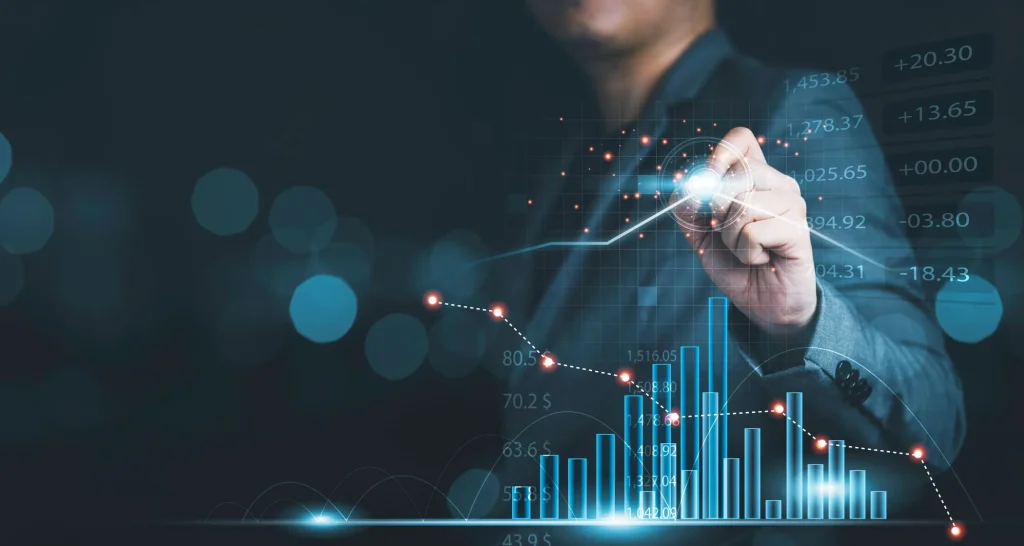 Mann im Anzug tippt in einem Chart mit steigendem Kurs auf den höchsten Punkt als Zeichen für einen hohen Wert (Value)