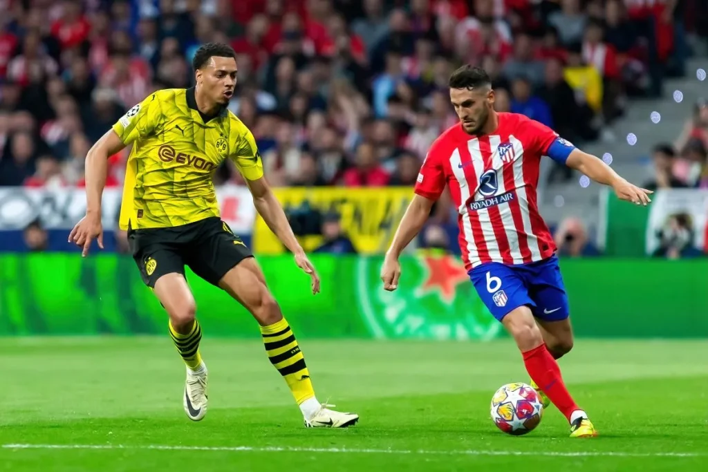 Spieler von Borussia Dortmund und Atlético Madrid im Laufduell bei einem Spiel in der Champions League