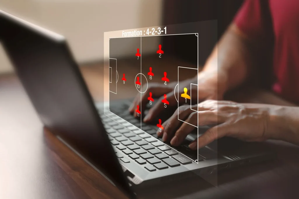 Spielfeld mit Fußballsimulation neben einem Mann am Laptop als Zeichen für eine Systemwetten Erklärung