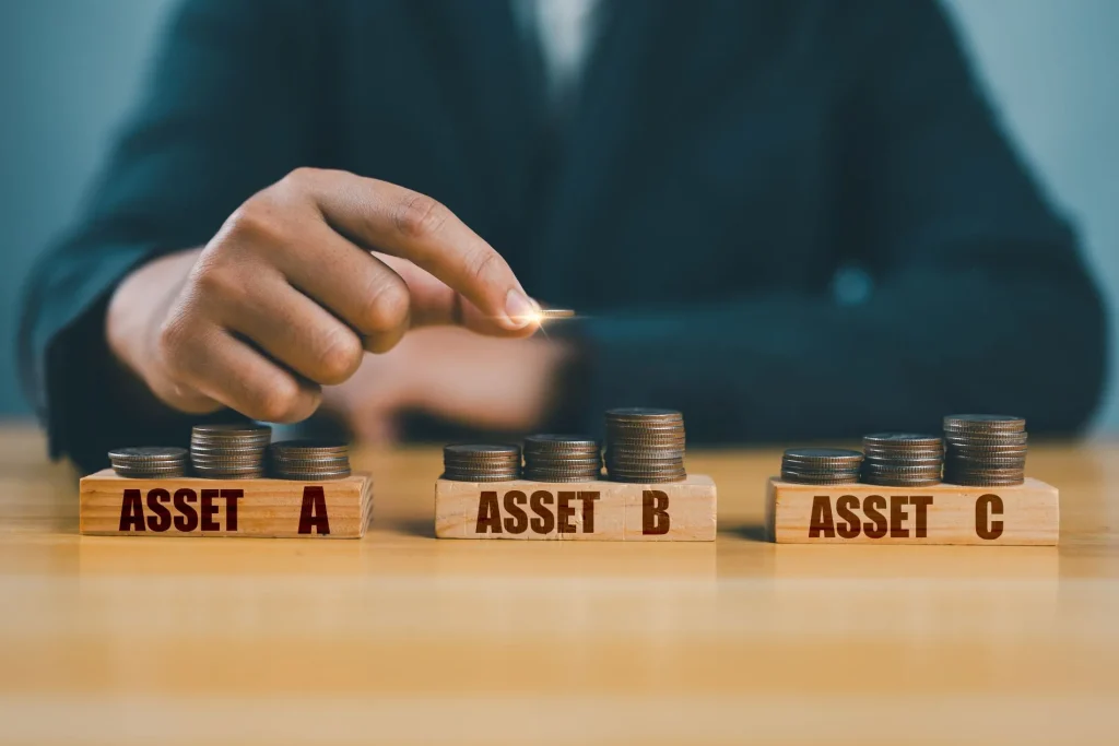 Mann tut Münzen auf Stapel mit verschiedenen Assets (Anlagen), um mit weniger Risiko Geld mit Sportwetten zu verdienen